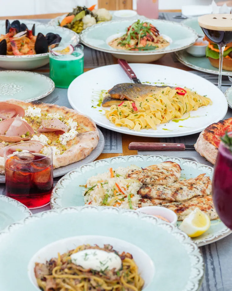 Table spread of pasta, seafood, pizza, and grilled dishes at d'angelo